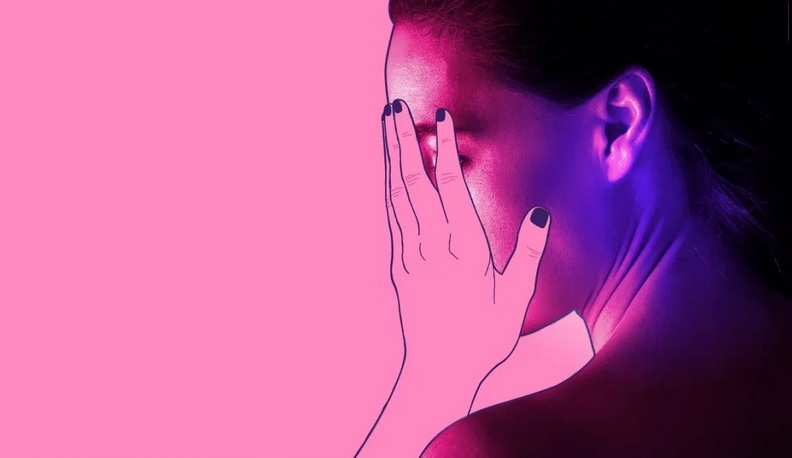 Mujer cubriéndose el rostro con la mano izquierda