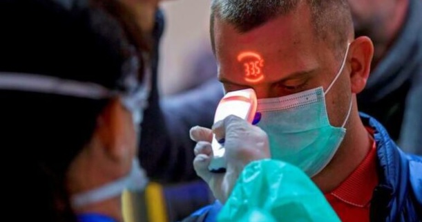 Profesional sanitario tomando la temperatura en la frente con un NCIT