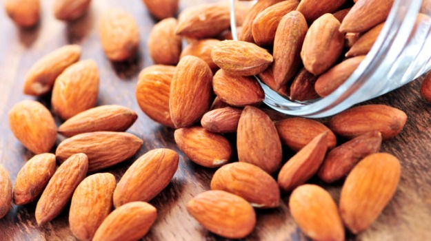 Almendras larguetas crudas con piel depositadas sobre mesa