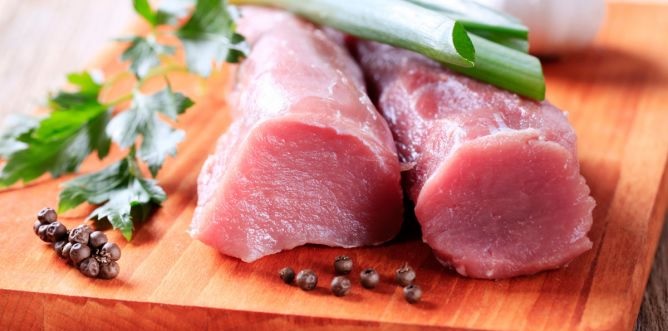 Fotografía solomillo de cerdo crudo sobre tabla de cocina