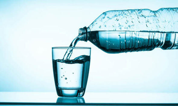 Agua saliendo de una botella y siendo vertida en un vaso