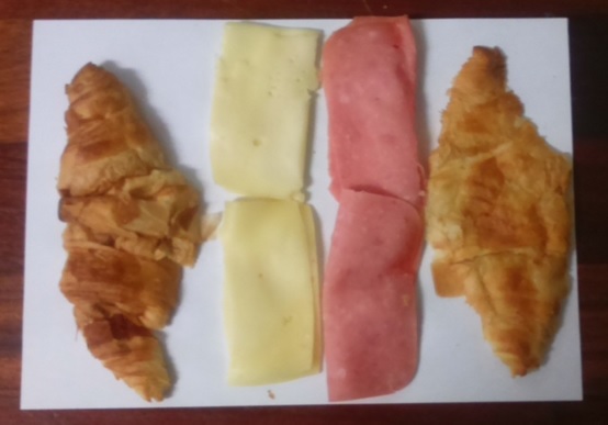Fotografía a vista de pájaro de los ingredientes del pincho cruasán de mortadela y queso manchego fresco