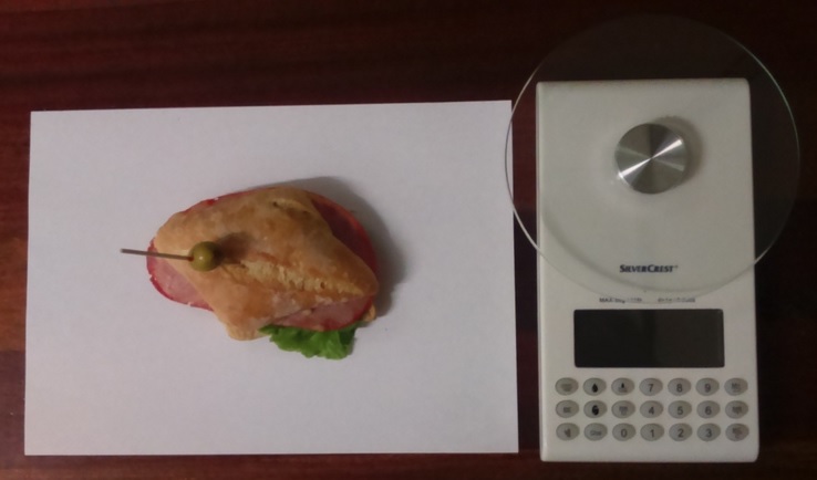Fotografía a vista de pájaro del pincho Lomo de cerdo tipo Sajonia con lechuga y báscula digital