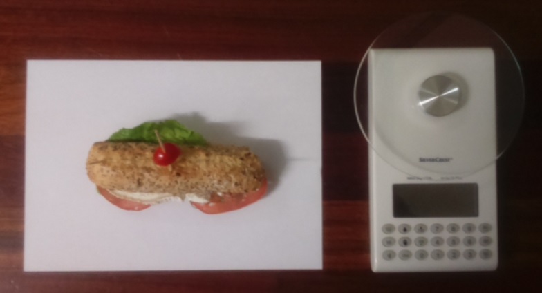 Fotografía a vista de pájaro del pincho queso de cabra de pasta blanda con tomate y báscula digital