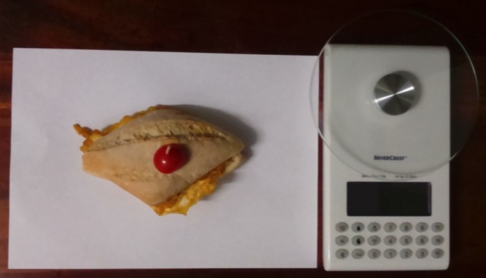Fotografía a vista de pájaro del pincho Tortilla francesa rellena de chorizo y báscula digital