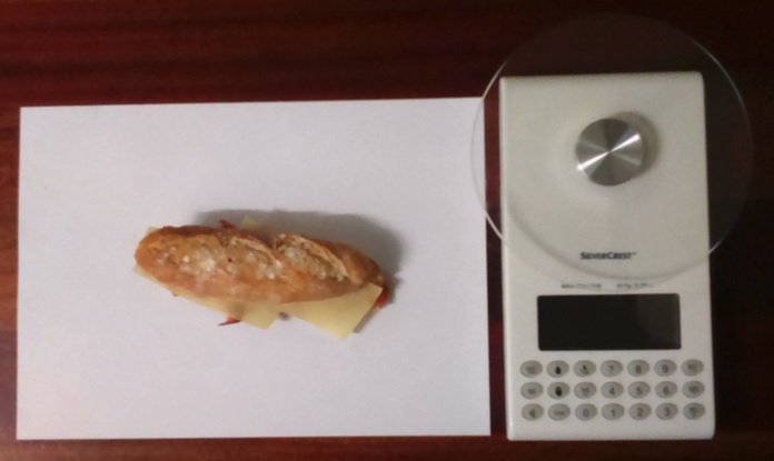Fotografía a vista de pájaro del pincho Txiki de jamón serrano y queso semicurado y báscula digital